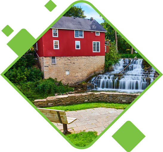 Red-house-in-Honeoye-Falls-with-waterfall-and-park-bench